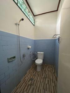 a bathroom with a toilet and a shower at Bagus Homestay in Padangbai