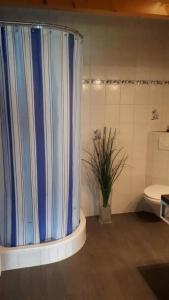 uma casa de banho com uma cortina de chuveiro azul e um WC. em schöner Aufenthalt em Le Noirmont