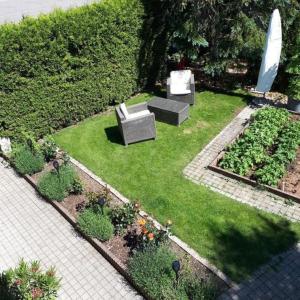 a garden with two couches and some plants at schöner Aufenthalt in Le Noirmont