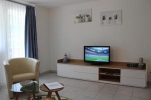 sala de estar con TV y silla en Topwohnung für 2 - 3 Personen mit einem getrennten Schlafzimmer en Saas-Almagell