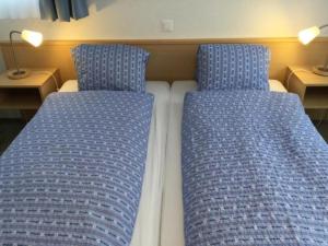 dos camas sentadas una al lado de la otra en una habitación en Topwohnung für 2 - 3 Personen mit einem getrennten Schlafzimmer en Saas-Almagell