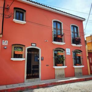 a red building with windows and a door at 7 orejas in Quetzaltenango