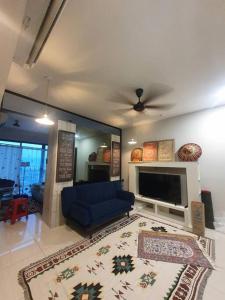 ein Wohnzimmer mit einem blauen Sofa und einem TV in der Unterkunft Studio near KLCC and LRT with superb view in Kuala Lumpur