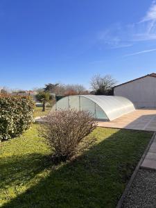 uma vista para um edifício com um arbusto num quintal em Villa de 3 chambres avec piscine privee jardin clos et wifi a Saint Froult a 1 km de la plageB em Saint-Froult