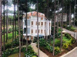 a house in the middle of a forest of trees at Omirita Resort Dalat in Da Lat