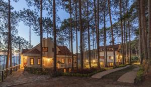 a house in the woods with its lights on at Omirita Resort Dalat in Da Lat