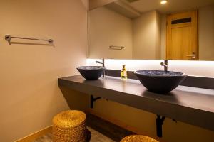 a bathroom with two sinks and a mirror at Kawaguchiya Kinosaki Riverside Hotel in Toyooka