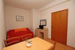 Habitación pequeña con mesa y sofá rojo. en Apartments Adrion, en Drasnice