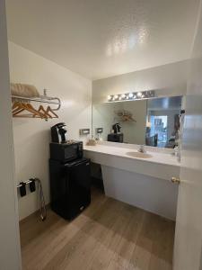 a bathroom with a sink and a large mirror at The Virginian Inn Moab Downtown in Moab