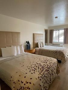 a hotel room with two beds and a window at The Virginian Inn Moab Downtown in Moab