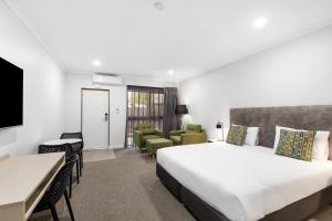 a hotel room with a large bed and a desk at Presidential Motel in Mount Gambier