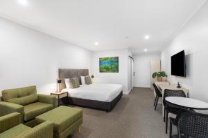 a hotel room with a bed and a table and chairs at Presidential Motel in Mount Gambier