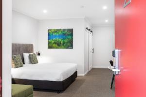 1 dormitorio con 1 cama y una pintura en la pared en Presidential Motel, en Mount Gambier