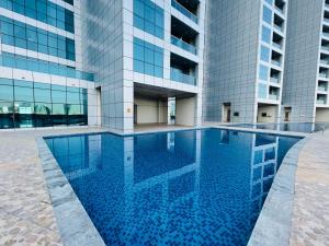 une piscine en face d'un bâtiment dans l'établissement Beachfront paradise just minutes from Dubai, à Ajman