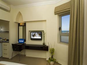 a room with a desk with a television and a window at Bell Boutique and Spa Hotel in Tel Aviv