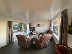 a living room with two chairs and a table at Home with a view in Otorohanga