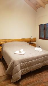 1 dormitorio con 1 cama con 2 toallas en EL SUSURR0 en Villa Pehuenia