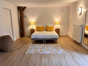 - une chambre avec un lit doté d'oreillers jaunes et d'un tapis dans l'établissement Le domaine de Marie, à Port-sur-Saône