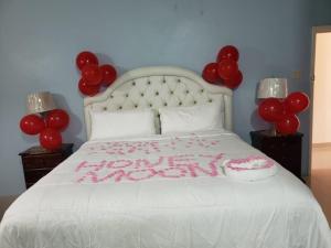 a bedroom with a bed with red balloons on it at Dela de-Rose Guest House Negril Jamaica in Negril