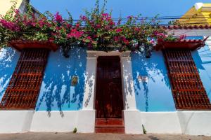 un edificio azul con cestas de flores. en Casa Pedro Romero, en Cartagena de Indias