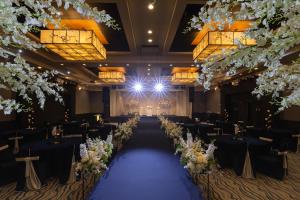 um salão de banquetes com mesas pretas e flores brancas em Sono Belle Jeju em Jeju