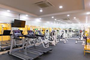 a gym with several tread machines and a flat screen tv at Sono Belle Jeju in Jeju