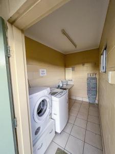 a small laundry room with a washer and dryer at Nanango Antler Motel in Nanango