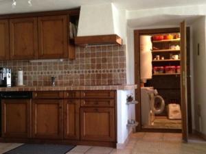 una cucina con armadi in legno e frigorifero di Ursprüngliches, stilvolles Rustico a Malvaglia