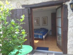 una camera da letto con porta che conduce a un letto di Ursprüngliches, stilvolles Rustico a Malvaglia