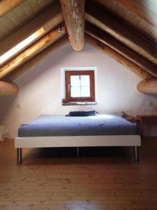 una camera da letto con un letto in mansarda con una finestra di Ursprüngliches, stilvolles Rustico a Malvaglia