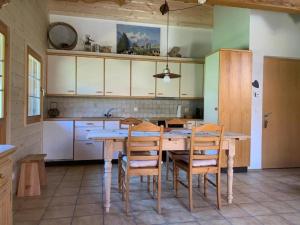 3 12 Zimmer Wohnung في اكسالب: مطبخ مع طاولة وكراسي خشبية