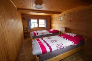 2 camas en una cabaña de madera con ventana en Bauernhof Hasenbüel en Sankt Peterzell