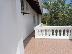 a white balcony with a white railing on a house at Casa de la Amistad in Areguá