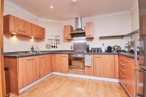 a kitchen with wooden cabinets and stainless steel appliances at Free Parking-Central-Contractors-Leisure in Coventry