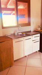 cocina con fregadero y ventana en Boa Vibe Complexo Rosa Norte, en Praia do Rosa