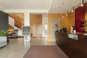 kobieta siedząca przy ladzie w holu w obiekcie Wellness Hotel ABÁCIE w Nowym Jiczynie