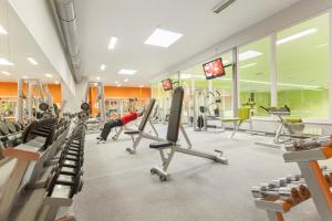 siłownia ze sprzętem do ćwiczeń wysiłkowych i osoba ćwicząca w siłowni w obiekcie Wellness Hotel ABÁCIE w Nowym Jiczynie