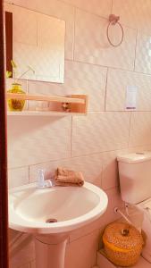 uma casa de banho com um lavatório branco e um WC. em Boa Vibe Complexo Rosa Norte na Praia do Rosa