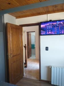 的住宿－Rodeo suite，一间设有门的房间和墙上的电视