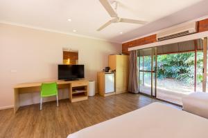 a room with a desk with a television and a green chair at Contour Hotel Katherine in Katherine