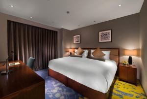 Gulta vai gultas numurā naktsmītnē Oakwood Hotel & Residence Suzhou