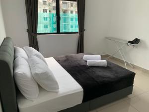 um quarto com uma cama com almofadas e uma janela em Desaru Utama Apartment with Swimming Pool View, Karaoke, FREE WIFI, Netflix, near to Car Park em Desaru