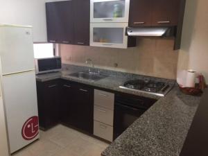 uma cozinha com um lavatório, um fogão e um frigorífico em Exclusive Furnished Apartment 6 em Manizales