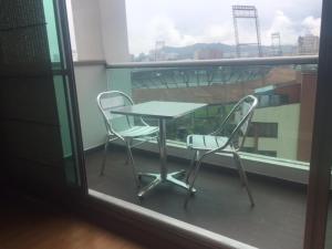 uma mesa e duas cadeiras sentadas numa varanda em Exclusive Furnished Apartment 6 em Manizales