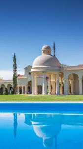 a building with a dome on top of a swimming pool at Finca El Recreo in Cafayate