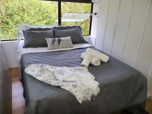 a bed in a room with two pillows on it at ÉCOisa de Chácara - Casa de Vidro, Casa de Campo in Morretes