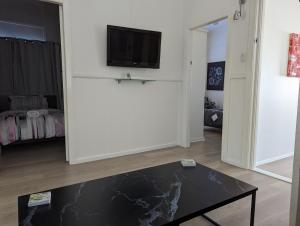 a living room with a black table and a tv at Waterside Retreat - Blackies Beach - Swansea Channel in Blacksmiths