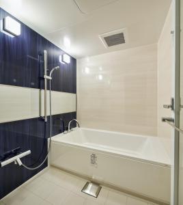 a bathroom with a bath tub and a shower at BEB5 Okinawa Seragaki by Hoshino Resorts in Onna