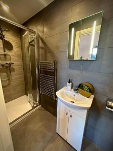 a bathroom with a white sink and a shower at Room with private bathroom/Tv in Purley