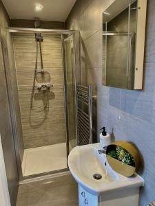 a bathroom with a shower and a white sink at Room with private bathroom/Tv in Purley